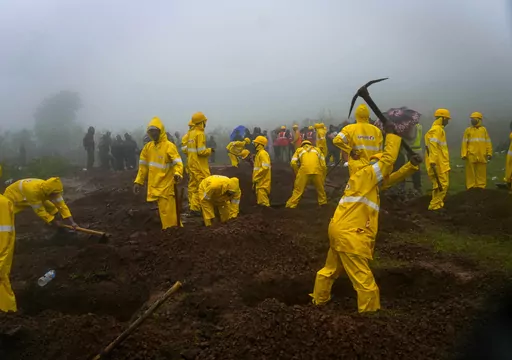 Rescuers dig graves to bury the bodies of victims at the site of a landslide in Raigad district, western Maharashtra state, India, Thursday, July 20, 2023. While some people are reported dead many others feared trapped under piles of debris. (AP Photo/Rafiq Maqbool)