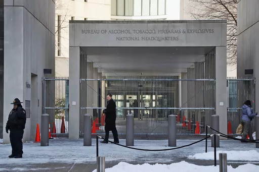 In this Thursday, Jan. 23, 2014 photo, a security official walks in front of the entrance to the national headquarters of the Bureau of Alcohol, Tobacco, Firearms and Explosives in Washington. On Friday, March 1, 2024, The Associated Press reported on stories circulating online incorrectly claiming an update to the Bureau of Alcohol, Tobacco, Firearms and Explosives’ background check policy allows people in the U.S. illegally to purchase firearms. (AP Photo/Charles Dharapak, File)