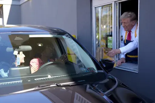 Republican presidential nominee former President Donald Trump hands an order to a customer at a drive-thru window during a campaign stop at a McDonald's, Sunday, Oct. 20, 2024, in Feasterville-Trevose, Pa. (AP Photo/Evan Vucci)