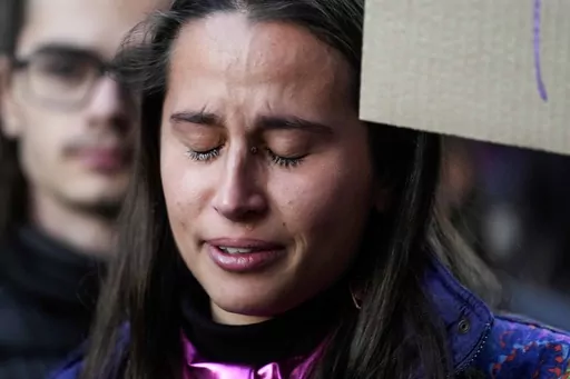 A student cries during a flash mob 'A minute of noise for Giulia' for Giulia Cecchettin, allegedly killed at the hands of her possessive ex-boyfriend, outside the Statale University, in Milan, Italy, Wednesday, Nov. 22, 2023. Outrage over violence against women is mounting in Italy, with students leading the way. Young people across the country have taken to pounding on classroom desks in unison to demand an end to the slayings of women by men and to root out corrosive, patriarchal attitudes tha