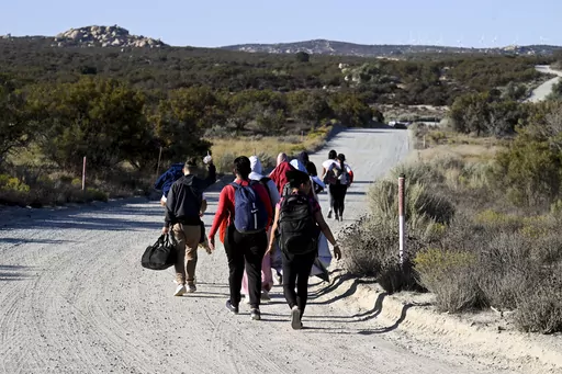 Asylum-seekers walk to a U.S. Border Patrol van after crossing the nearby border with Mexico, Tuesday Sept. 26, 2023, near Jacumba Hot Springs, Calif. Migrants continue to arrive to desert campsites along California's border with Mexico, as they await processing. Congress is discussing changes to the immigration system in exchange for providing money to Ukraine in its fight against Russia and Israel for the war with Hamas. (AP Photo/Denis Poroy, File)
