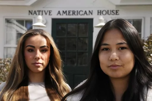 Dartmouth College students Marisa Joseph, right, a member of the Tulalip Tribes of Washington, poses with Ahnili Johnson-Jennings, left, a member of the Quapaw, Choctaw, Sac and Fox and Miami tribes, pose outside the Native American House at Dartmouth College, Friday, April 7, 2023, in Hanover, N.H. The college announced in March 2023 that it housed partial Native American skeletal remains in their collection. Dartmouth has set in motion an effort to repatriate the remains to the appropriate tri