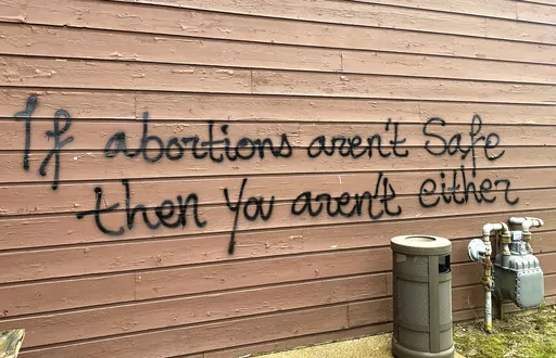 Threatening graffiti is seen on the exterior of Wisconsin Family Action offices in Madison, Wis., May 8, 2022. Investigators on Tuesday, March 28, 2023, finally captured the man they believe firebombed the prominent Wisconsin anti-abortion lobbying group's office last year ahead of the U.S. Supreme Court's decision to overturn its landmark Roe v. Wade ruling. The U.S. attorney's office in Madison announced that police arrested 29-year-old Hridindu Sankar Roychowdhury at Boston's Logan Internatio