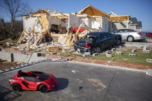 A child's toy car sits near damaged cars and homes Tuesday, Dec. 14, 2021, in Bowling Green, Ky., after a tornado touched down in the middle of the night. According to three different reports released Monday, Jan. 10, 2021, the United States staggered through a steady onslaught of deadly billion-dollar climate disasters in an extra hot 2021, while the nation’s greenhouse gas emissions last year jumped 6% because of surges in coal and long-haul trucking, putting America further behind its 2030 