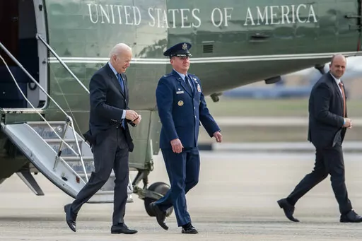 President Joe Biden escorted by Col. Matthew Jones, Commander of the 89th Airlift Wing, walks to board Air Force One at Andrews Air Force Base, Md., Wednesday, March 23, 2022. (AP Photo/Gemunu Amarasinghe)