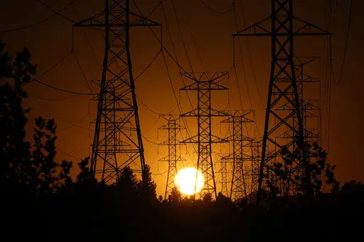 The sun sets behind high tension power lines on Sept. 23, 2024, in the Porter Ranch section of Los Angeles. (AP Photo/Mark J. Terrill, File)