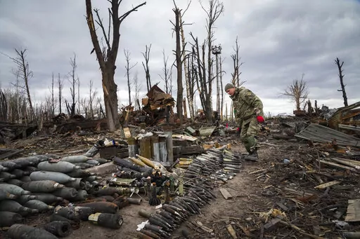 An interior ministry sapper collects unexploded shells, grenades and other devices in Hostomel, close to Kyiv, Ukraine, Monday, April 18, 2022. (AP Photo/Efrem Lukatsky)