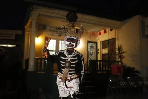 A member of the North Side Skull & Bone Gang starts the celebration with a wake up call for Mardi Gras at the Backstreet Cultural Museum, Feb. 9, 2016, in New Orleans. Ten months after Hurricane Ida damaged the museum celebrating New Orleans’ African American parading culture, it is reopening.  (AP Photo/Brynn Anderson, File)