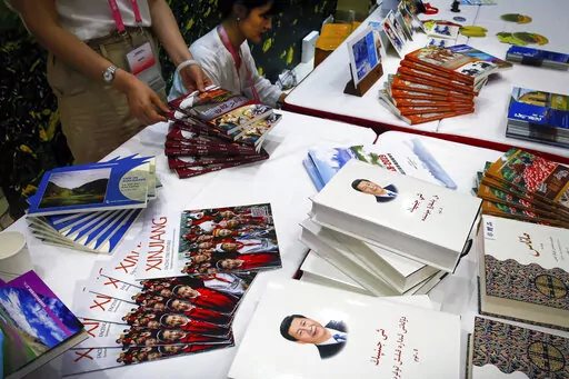 Copies of the book on the governance of Chinese President Xi Jinping are displayed with booklets promoting Xinjiang during a news conference by Shohrat Zakir, chairman of China's Xinjiang Uighur Autonomous Region, at the State Council Information Office in Beijing on July 30, 2019. As the Chinese government tightened its grip over its ethnic Uyghur population, it sentenced one man to death and three others to life in prison in 2021 for textbooks drawn in part from historical resistance movements