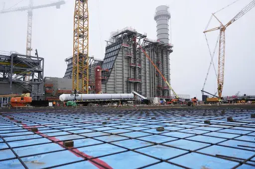 The foundation for a warehouse is visible in the foreground at Entergy's Orange County Advanced Power Station, a 1,215-megawatt facility under construction, Monday, Feb. 24, 2025, in Orange, Texas. (AP Photo/David J. Phillip)