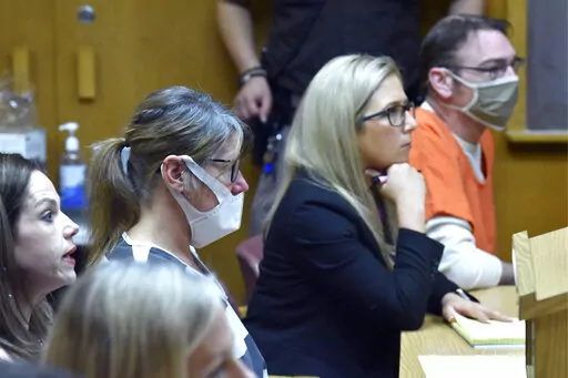 Shannon Smith, from left, defense attorney for Jennifer Crumbley, and Mariell Lehman, defense attorney for Jennifer's husband, James Crumbley, right, listen as Judge Cheryl Matthews denies the request to lower their bond, Tuesday, April 19, 2022, in Pontiac, Mich. The judge denied a motion to reduce bonds for the jailed parents of a Michigan teenager who is charged in a shooting at Oxford High School that left four of his fellow students dead. (Todd McInturf/Detroit News via AP)