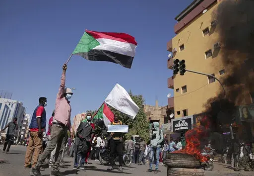 People chant slogans during a protest to denounce the October 2021 military coup, in Khartoum, Sudan, Tuesday, Jan. 4, 2022. Sudanese took to the streets in the capital, Khartoum, and other cities on Tuesday in anti-coup protests as the country plunged further into turmoil following the resignation of the prime minister earlier this week. (AP Photo/Marwan Ali)
