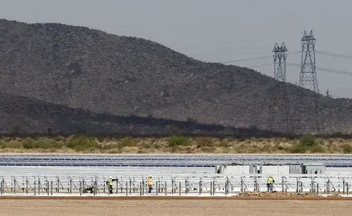 Workers continue to build rows of solar panels at a Mesquite Solar 1 facility under construction in Arlington, Ariz., Sept. 30, 2011. One of President Joe Biden's signature laws aimed to invigorate renewable energy manufacturing in the U.S. It will also helped a solar panel company reap billions of dollars. Arizona-based First Solar is one of the biggest early winners from the Democrats' Inflation Reduction Act, offering a textbook case of how the inside influence game works in Washington.(AP Ph