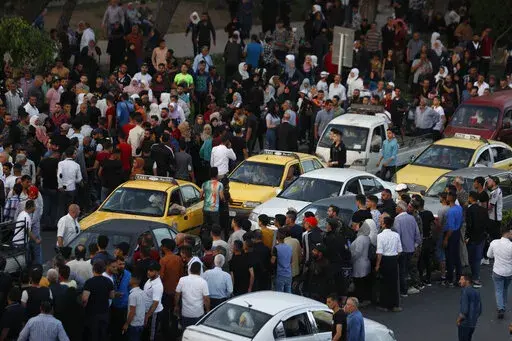 Dozens of Syrians wait at the President's Bridge in Damascus for relatives they hope would be among those released from prison May 3, 2022, on the second day of the Muslim Fitr holiday. A newly released video taken in 2013 showed blindfolded men who were thrown into a large pit and shot dead by Syrian agents, who then set the bodies on fire. The video stirs new fears over the fate of tens of thousands who went missing during Syria's long-running conflict and serves as a grim reminder of the war'