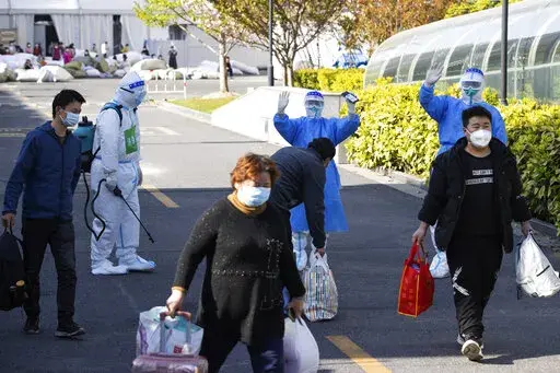 In this photo released by Xinhua News Agency, the first group of patients who have recovered from COVID-19 leave a makeshift hospital converted from Shanghai Convention & Exhibition Center of International Sourcing in Shanghai on Saturday, April 9, 2022. Shanghai on Sunday discharged over 11,000 recovered COVID-19 patients and health authorities emphasized that they must be allowed to return home despite the lockdown that has severely restricted movement in China's largest city. (Jin Liwang/Xinh