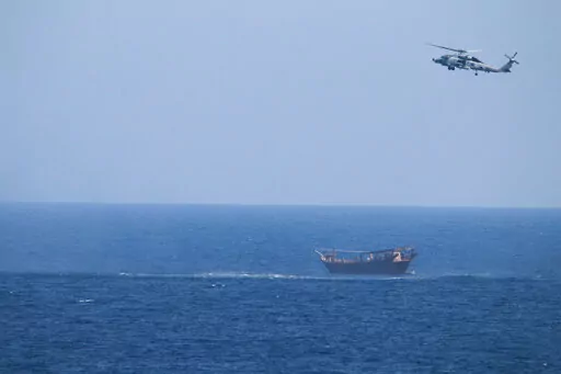 A U.S. Navy Seahawk helicopter flies over a stateless dhow later found to be carrying a hidden arms shipment in the Arabian Sea, May 6, 2021. The U.S. Navy's Mideast-based 5th Fleet will begin Tuesday, July 5, 2022, to offer rewards for information that could help sailors intercept weapons, drugs and other illicit shipments across the region. The program launches against the backdrop of tensions over Iran’s nuclear program and Tehran’s arming of Yemen’s Houthi rebels. (U.S. Navy via AP, Fi