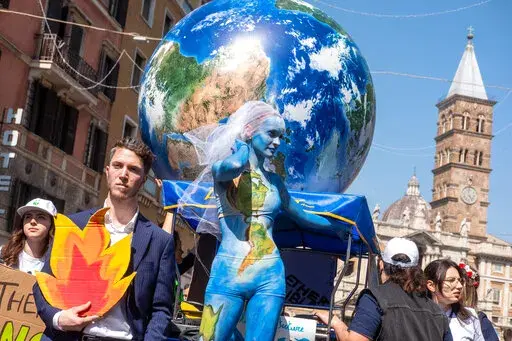 Demonstrators of the Fridays for Future movement march in downtown Rome, Friday, March 25, 2022. Climate activists staged a tenth series of worldwide protests Friday to demand leaders take stronger action against global warming, with some linking their environmental message to calls for an end to the war in Ukraine. (Mauro Scrobogna/LaPresse via AP)