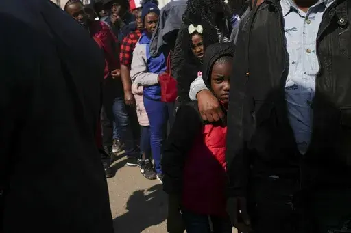 Migrants from Haiti stand in line outside the Mexican Commission for Refugee Aid (COMAR) government office to apply for asylum in Mexico City, Tuesday, Jan. 28, 2025. (AP Photo/Marco Ugarte)