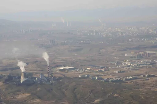 Smoke and steam rise from towers at the coal-fired Urumqi Thermal Power Plant as seen from a plane in Urumqi in western China's Xinjiang Uyghur Autonomous Region on April 21, 2021. China is promoting coal-fired power as the ruling Communist Party tries to revive a sluggish economy, prompting warnings that Beijing is setting back efforts to cut climate-changing carbon emissions from the biggest global source. (AP Photo/Mark Schiefelbein, File)