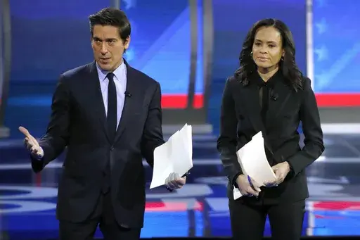 ABC World News Tonight Anchor David Muir, left, addresses members of the audience while standing with ABC News Live Anchor Linsey Davis, Friday, Feb. 7, 2020 in Manchester, N.H. (AP Photo/Elise Amendola, File)