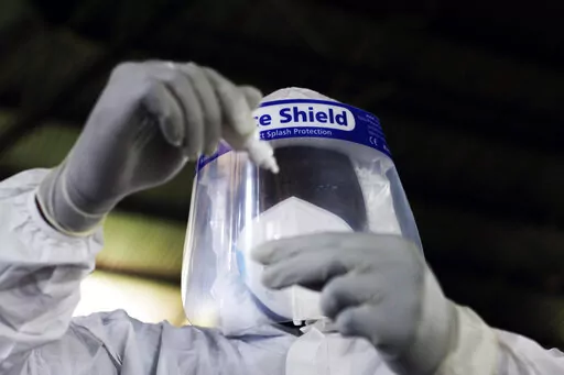 A health official takes a sample for tests at a private Covid-19 testing centre in Harare, Zimbabwe, Thursday, Feb, 3, 2022. African nations have very limited access to COVID-19 tests, especially at-home tests. In the absence of vaccines, that discrepancy has denied millions of poor people an easy way to stem the spread of the coronavirus, health officials say. (AP Photo/Tsvangirayi Mukwazhi)