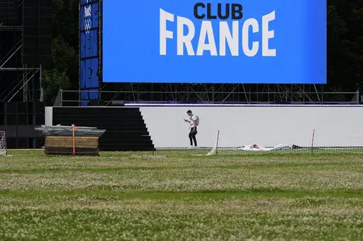 A person walks near a stage at France's house at Parc de la Villette ahead of the 2024 Summer Olympics, Tuesday, July 23, 2024, in Paris, France. (AP Photo/Natacha Pisarenko)