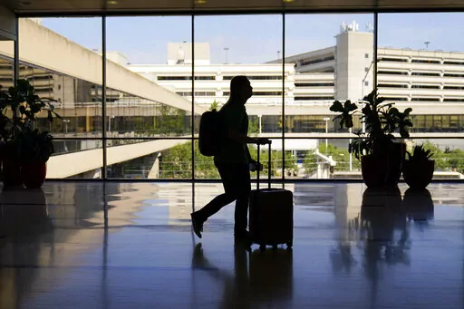 A traveler moves through the Philadelphia International Airport ahead of the Independence Day holiday weekend in Philadelphia, Friday, July 1, 2022.  The concept of “going home for the holidays” changes throughout your life, and many millennials are currently going through that transition. (AP Photo/Matt Rourke, File)