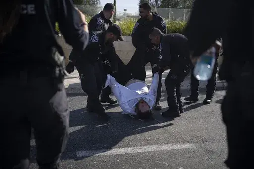 Israeli police officers remove an ultra-Orthodox Jewish man from the street during a protest against army recruitment in Jerusalem on June 2, 2024. Israel’s Supreme Court on Tuesday, June 25, ruled unanimously that the military must begin drafting ultra-Orthodox men for military service, a decision that could lead to the collapse of Prime Minister Benjamin Netanyahu’s governing coalition as Israel continues to wage war in Gaza. (AP Photo/Leo Correa, File)