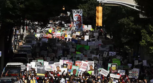People march down the street towards the Georgia state Capitol to protest against the mistreatment of black people and to press for policy change, on June 15, 2020 in Atlanta.  The NAACP, the nation's oldest civil rights organization said it will propose a sweeping plan meant to protect Black Americans from white supremacist violence, in response to a hate-fueled massacre that killed 10 Black people in Buffalo, New York last weekend.(AP Photo/Brynn Anderson, File)