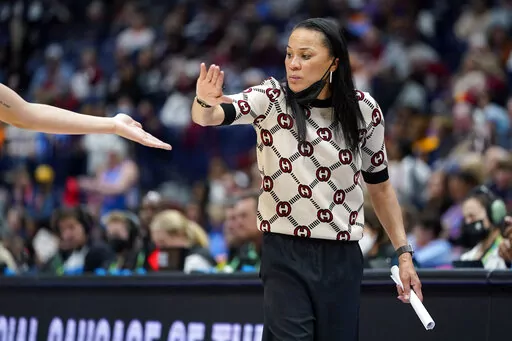 South Carolina head coach Dawn Staley congratulates a player during the second half of an NCAA college basketball semifinal round game against Mississippi at the women's Southeastern Conference tournament Saturday, March 5, 2022, in Nashville, Tenn. South Carolina won 61-51. (AP Photo/Mark Humphrey)