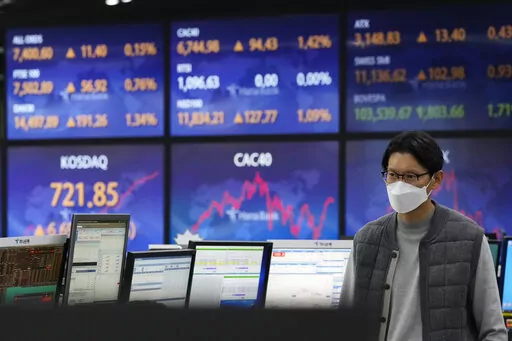 A currency trader passes by the screens showing the foreign exchange rates at the foreign exchange dealing room of the KEB Hana Bank headquarters in Seoul, South Korea, Wednesday, Dec. 14, 2022. Stocks rose Wednesday in Asia after a rally on Wall Street spurred by news that inflation in the U.S. cooled more than expected last month. (AP Photo/Ahn Young-joon)