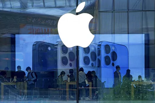 People shop at an Apple Store in Beijing, Tuesday, Sept. 28, 2021. Apple disclosed serious security vulnerabilities Wednesday, Aug. 17, 2022 for iPhones, iPads and Macs. The software flaws could potentially allow attackers to take complete control of these devices, Apple said.  (AP Photo/Andy Wong, File)
