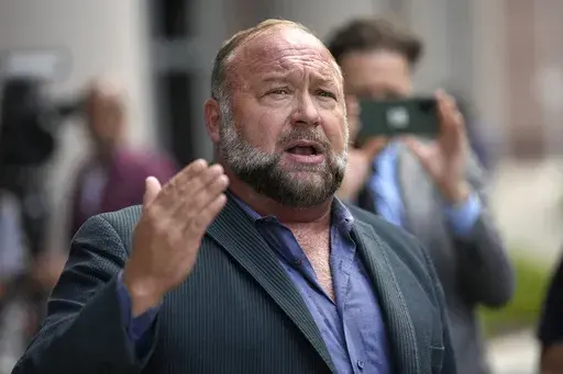 Alex Jones speaks to the media after arriving at the federal courthouse for a hearing in front of a bankruptcy judge, June 14, 2024, in Houston. (AP Photo/David J. Phillip, File)