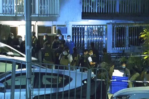In this image taken from video footage provided by TVB Hong Kong, police officers search a village home where they found body parts related to a missing model in a murder case, in Hong Kong on Sunday, Feb. 26, 2023. Police in Hong Kong have filed murder charges against the former in-laws of a model, days after her body parts were found in a refrigerator. A police statement says Hong Kong model Abby Choi’s father-in-law and his eldest son are being charged with murder, while her mother-in-law f