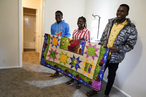 Refugees from Congo Sadock Ekyochi, from left, his wife Riziki Kashindi and her brother Kaaskile Kashindi pose for a photo inside their new apartment, Thursday, April 11, 2024, in Columbia, S.C. The American refugee program, which long served as a haven for people fleeing violence around the world, is rebounding from years of dwindling arrivals under former President Donald Trump. The Biden administration has worked to restaff refugee resettlement agencies and streamline the process of vetting a