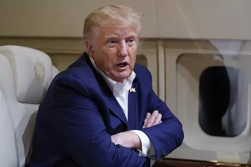 Former President Donald Trump speaks with reporters while in flight on his plane after a campaign rally at Waco Regional Airport, in Waco, Texas, March 25, 2023, while en route to West Palm Beach, Fla. (AP Photo/Evan Vucci, File)