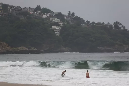 Tourists swim in Acapulco, Mexico, Tuesday, Oct. 24, 2023. Hurricane Otis has strengthened from tropical storm to a major hurricane in a matter of hours as it approaches Mexico's southern Pacific coast where it was forecast to make landfall near the resort of Acapulco early Wednesday. (AP Photo/Bernardino Hernandez)