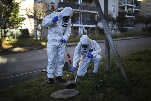 Firefighters from the Marins-Pompiers of Marseille extract samples of sewage water at a retirement home in Marseille, southern France, Thursday Jan. 14, 2021, to trace concentrations of COVID-19 and the highly contagious variant that has been discovered in Britain. As coronavirus infections rise in some parts of the world, experts are watching for a potential new COVID-19 surge in the U.S. — and wondering how long it will take to detect. (AP Photo/Daniel Cole)