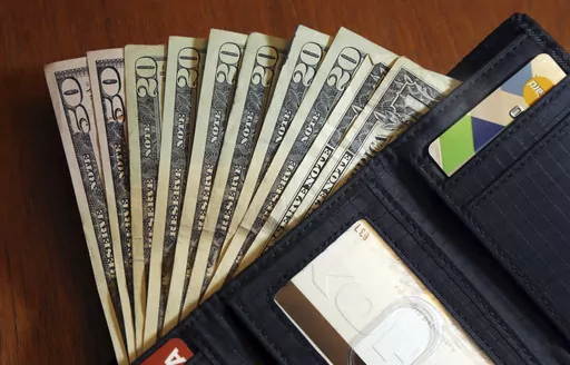 Cash is fanned out from a wallet in North Andover, Mass., June 15, 2018. Parenting comes with many responsibilities, and one is raising financially independent kids. Generally, it’s best to leave the money in your retirement accounts safely tucked away. Withdrawing money early can trigger taxes and a 10% penalty, plus it can cut into what you otherwise would’ve had for retirement. (AP Photo/Elise Amendola, File)