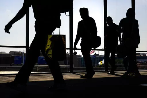 Arriving passengers move toward the baggage claim area at Philadelphia International Airport in Philadelphia on Friday, July 1, 2022. Travelers will probably pay more for airline tickets or a hotel room around the holidays than they did over last Thanksgiving or Christmas. (AP Photo/Matt Rourke, File)