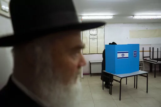 An Ultra-Orthodox Jewish man votes for Israel's parliamentary election at a polling station in Bnei Brak, Israel, Tuesday, Nov. 1, 2022. Israel is holding its fifth election in less than four years. (AP Photo/Oded Balilty)