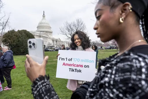 Devotees of TikTok, Mona Swain, center, and her sister, Rachel Swain, right, both of Atlanta, pose with a sign at the Capitol in Washington, March 13, 2024. TikTok's extensive lobbying campaign is the latest tech industry push since the House passed legislation that would ban the popular app if its China-based owner doesn't sell its stake. TikTok has been urging its users to call their representatives. (AP Photo/J. Scott Applewhite, File)