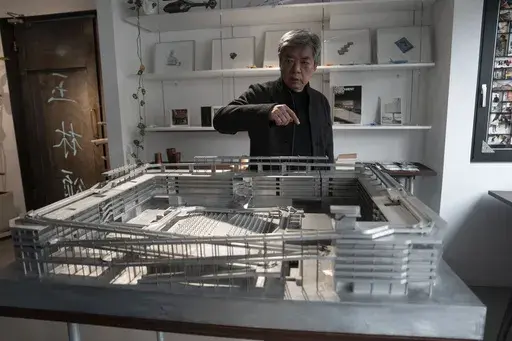 Pritzker Architecture Prize winner Chinese architect Liu Jiakun interacts with a scale model of the West Village project at his office in Chengdu in southwestern China's Sichuan province on Sunday, March 2, 2025. (AP Photo/Ng Han Guan)