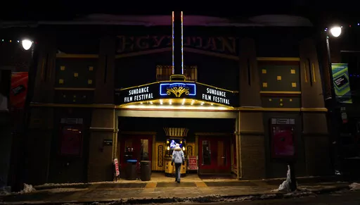 A pedestrian peers into the ticket booth of the Egyptian Theatre before the start of the 2023 Sundance Film Festival, Wednesday, Jan. 18, 2023, in Park City, Utah. The annual independent film festival runs from Jan. 19-29. (AP Photo/Chris Pizzello)