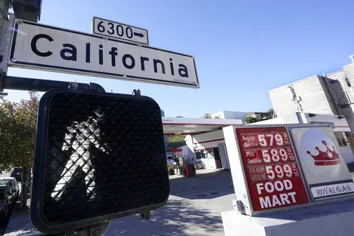 A California street sign is shown next to the price board at a gas station in San Francisco, on March 7, 2022. The average U.S. price of regular-grade gasoline shot up a whopping 79 cents over the past two weeks to $4.43 per gallon. Industry analyst Trilby Lundberg of the Lundberg Survey says Sunday, March 13, the new price exceeds by 32 cents the prior record high of $4.11 set in July 2008. Lundberg said gas prices are likely to remain high in the short term as crude oil costs soar amid global 