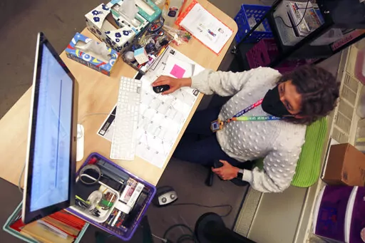 Art teacher Sarah Hager works at a computer in her classroom at Cleveland Middle School on Sunday, Jan. 23, 2022, in Albuquerque, N.M. Public school systems – which often have limited budgets and cybersecurity expertise -- have become an inviting target for ransomware gangs. The coronavirus pandemic has forced schools to turn increasingly toward virtual learning, making them more dependent on technology and more vulnerable to cyber-extortion. (AP Photo/Cedar Attanasio)