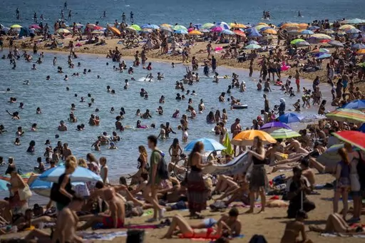 People cool off in the water on a hot and sunny day at the beach in Barcelona, Spain, July 15, 2022. Earth’s fever persisted last year, not quite spiking to a record high but still in the top five or six warmest on record, government agencies reported Thursday, Jan. 12, 2023. (AP Photo/Emilio Morenatti, File)