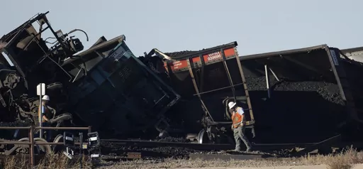 Workers toil to clear rail cars that derailed and collapsed a bridge over Interstate 25 northbound, Monday, Oct. 16, 2023, north of Pueblo, Colo. Federal investigators said Thursday they’re looking at BNSF Railway’s inspection and maintenance practices as the investigate the accident that killed a truck driver passing beneath the train. (AP Photo/David Zalubowski, File)