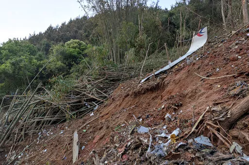 In this photo taken by mobile phone released by Xinhua News Agency, a piece of wreckage of the China Eastern's flight MU5735 are seen after it crashed on the mountain in Tengxian County, south China's Guangxi Zhuang Autonomous Region on Monday, March 21, 2022. A China Eastern Boeing 737-800 with 132 people on board crashed in a remote mountainous area of southern China on Monday, officials said, setting off a forest fire visible from space in the country's worst air disaster in nearly a decade. 