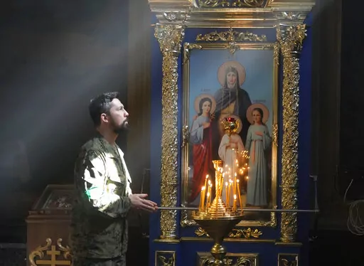 A Ukrainian soldier prays in St. Michael Cathedral during Easter celebration in Kyiv, Ukraine, Sunday, April 24, 2022. (AP Photo/Efrem Lukatsky)